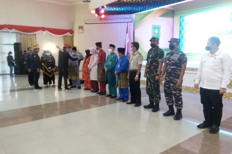 Deputi Bidang Penempatan dan Pelindungan Kawasan Amerika dan Pasifik BP2MI, Lasro Simbolon, saat memasangkan selempang pada Satgas Perlindungan dan Pencegahan Penempatan Ilegal PMI Riau, di Pekanbaru, Selasa (2/8). (Foto:Antara/Frislidia)