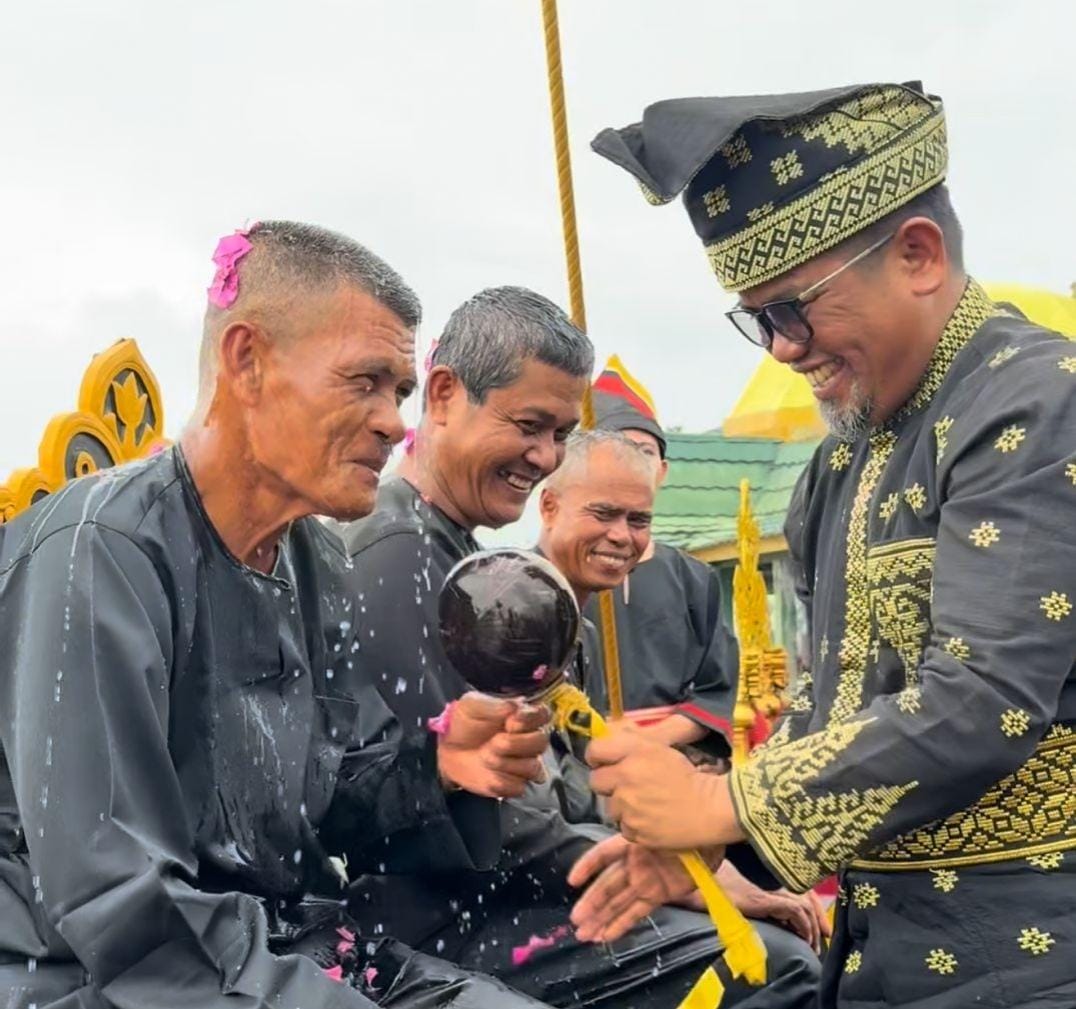 Bupati Pelalawan H. Zukri saat melaksanakan prosesi Mandi Belimau Sultan di Tepian Sungai Kampar, Minggu (15/2/2026).